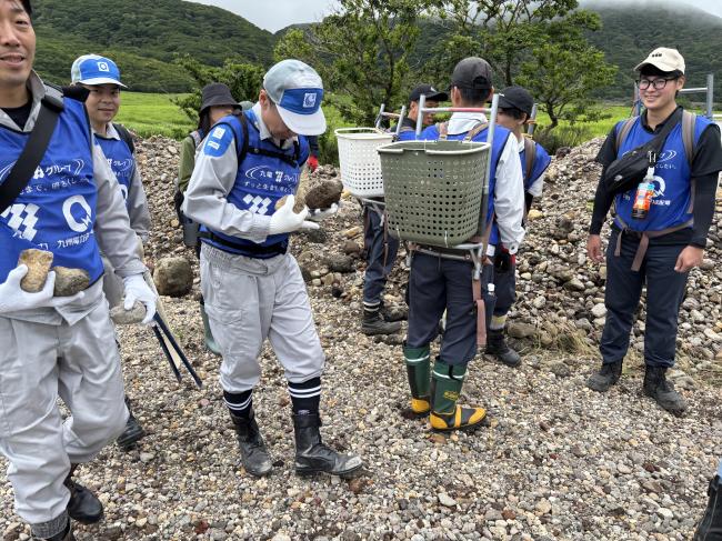 背負子にたくさんの石を入れ、それ以外の参加者は石を手に持って作業場所まで運びました